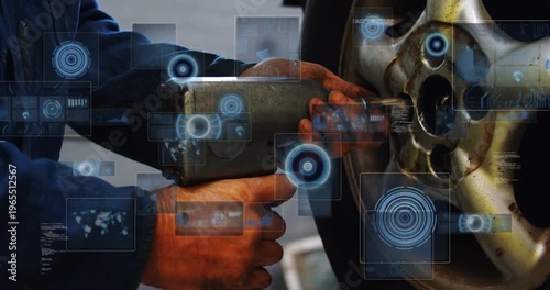 Mechanic steadying impact wrench and engaging loosening lug nut in garage while HUD overlaying