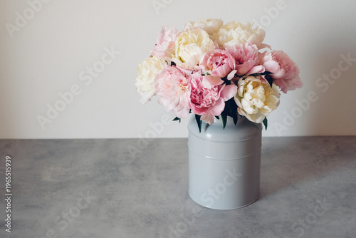 Beautiful bouquet of fresh colorful peonies in full bloom in vase. Floral spring still life. Copy space for text.