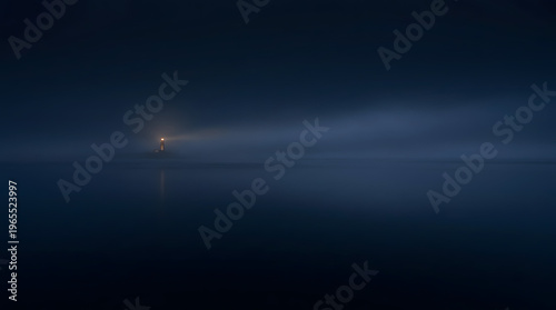 Dark moody seascape with distant glowing lighthouse
