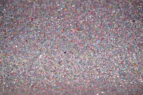 Colorful glitter texture background with sparkling particles in various shades and sizes