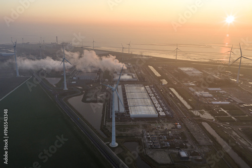 Aerial view of aerial view of a large hyperscale data center operating with surrounding wind turbines, showing cloud computing and ai infrastructure