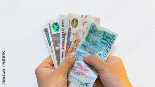 Obraz na płótnie Hands holding egyptian pound banknotes, illustrating financial concepts like inf
