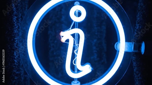 A glowing blue neon information symbol is illuminated within a circular frame, set against a dark, particle-filled background