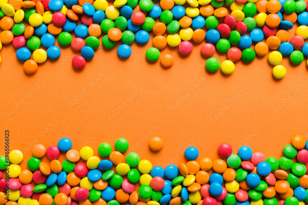 Obraz premium Mixed collection of colorful candy, on colored background. Flat lay, top view. frame of colorful chocolate coated candy