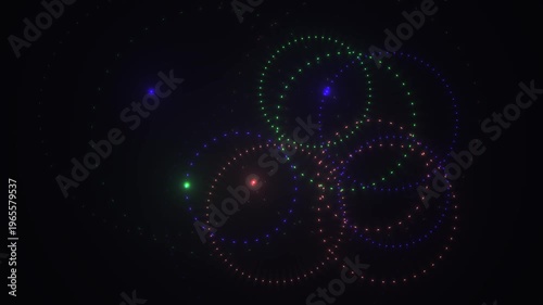 Abstract glowing particles forming circles on dark background with tiny stars