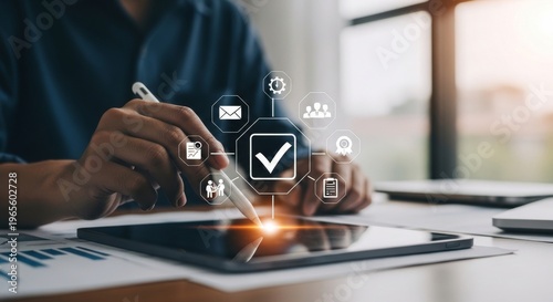 Close-up of hand using stylus on digital tablet with glowing icons for digital workflow, analytics, and project management