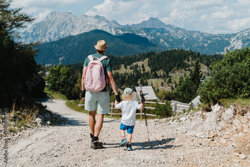 Fotografie Father and young son walking down a rocky mountain trail enjoying an active family vacation