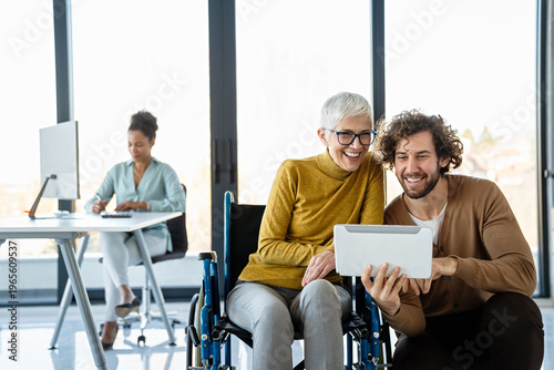 The image includes a person using a wheelchair, depicting inclusivity and teamwork in modern office