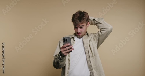 Confusion and discovery unfold as a man explores a mobile screen in a cozy studio setting