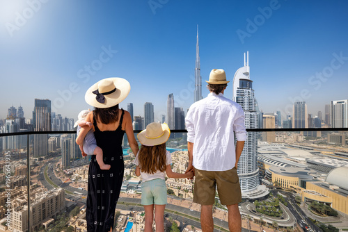 Photography A elegant family of four on a city break vacation enjoys the panoramic view over