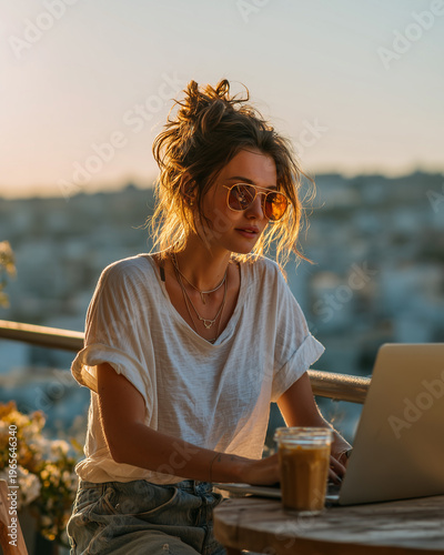Young professional working on laptop in sunny apartment.