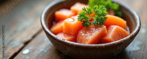 Cat food bowl with salmon chunks, tuna, and parsley garnish. Wet meal for feline, fresh seafood, healthy diet preparation, appetizing cat treat presentation.