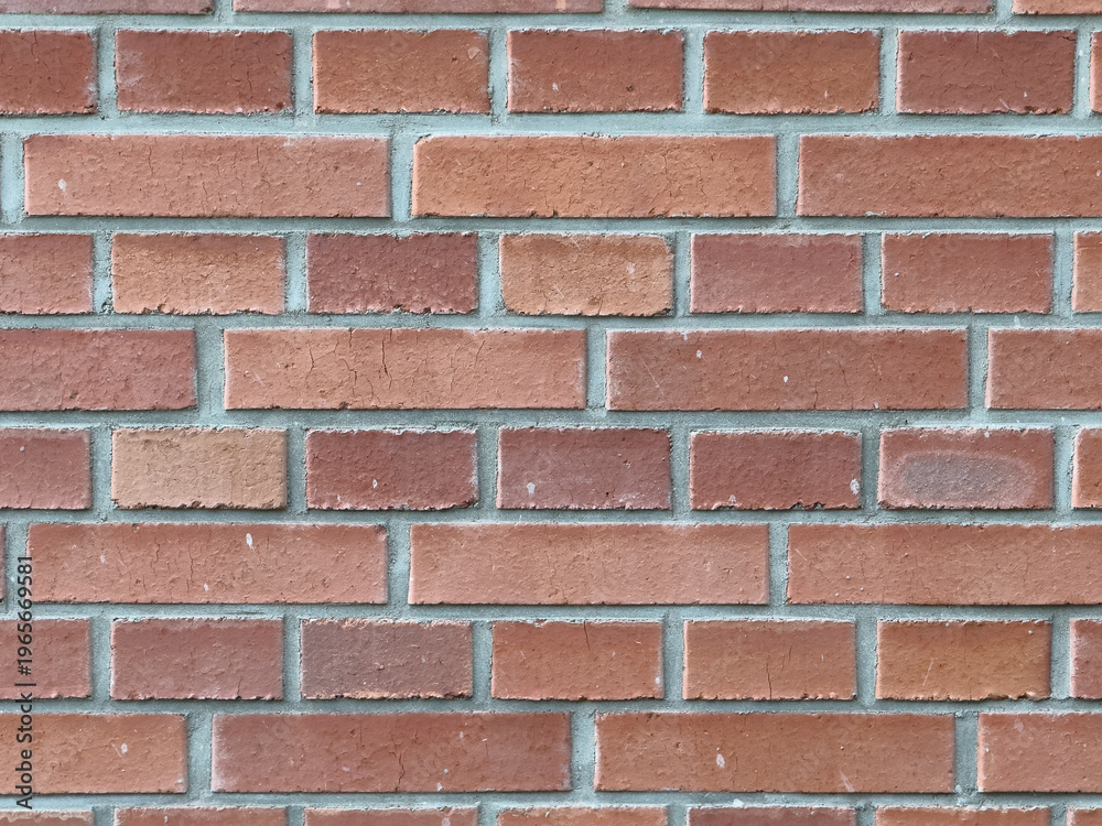 Obraz premium Brick wall with a pattern of alternating red and brown bricks during daylight