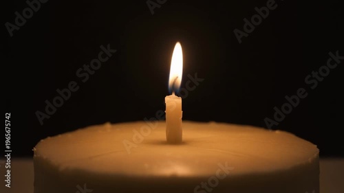 Single Candle Flame Glowing in Dark Minimal Setting
