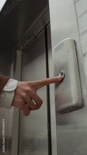 Vertical shot of young male office worker with dreaded hair wearing suit pressing elevator button and entering cabin in modern business center
