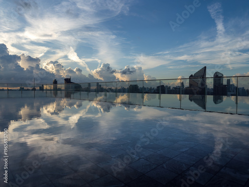 Rooftop infinity pool with city skyline reflection under dramatic morning sky, modern urban architecture and luxury lifestyle concept