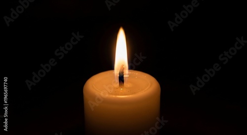Single lit candle in darkness.
