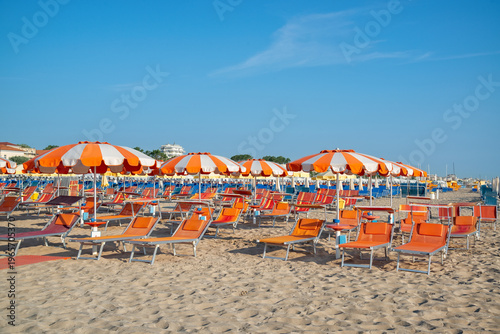 Vászonkép Bright beach scene with umbrellas and sun loungers at a coastal location during