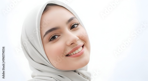 Close-up Portrait of Smiling Young Muslim Woman Wearing Light Grey Hijab Looking Up with Brown Eyes and Soft Focus on Face