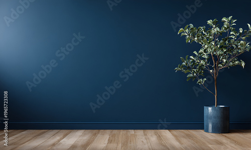 A simple, modern interior showcases a vibrant green-leafed tree in a blue pot against a dark blue wall. The space has wooden flooring