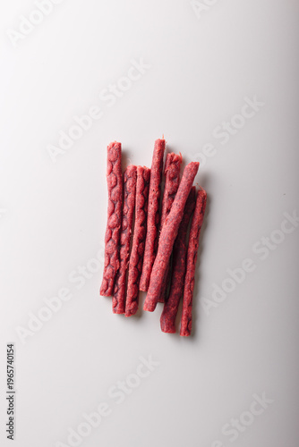 Dry salmon sticks heap, jerky fish meat pile on white background. Copy space, top view. Advertising banner, template. Product presentation. Vertical shot