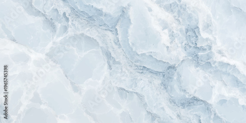 A vast blue ice texture background captures the abstract frozen patterns of winter nature under a cold sky with soft white snow and clouds on the water surface