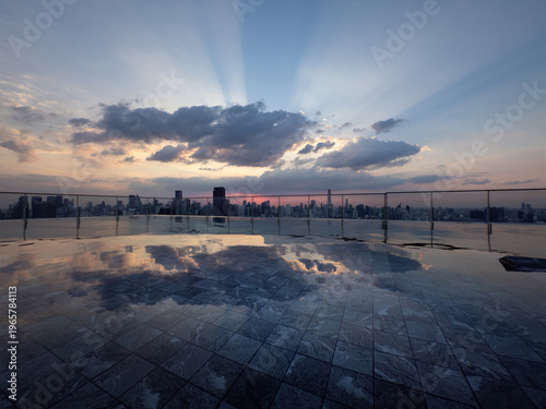 Rooftop infinity pool with city skyline reflection at sunset, dramatic clouds and sun rays over modern urban architecture, luxury lifestyle concept