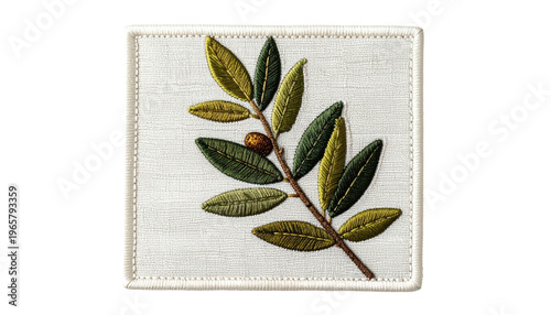 Embroidered square featuring an olive branch with green and yellow leaves, and a single brown olive on a light, textured background