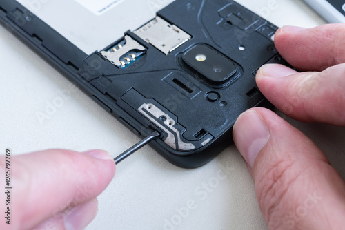 Man disassembling a cellphone with a screw driver