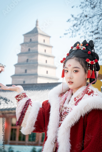 A woman dressed in Hanfu stands in front of the Big Wild Goose Pagoda in Xi'an