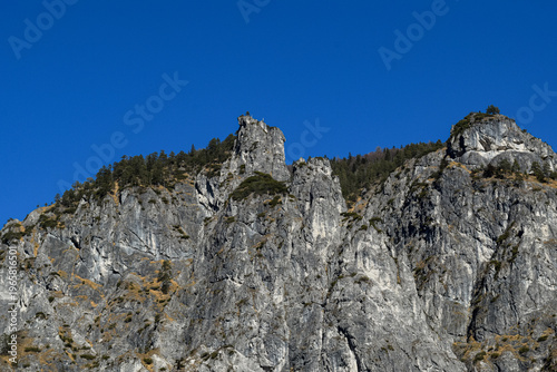 Photos Rocky cliff formation under deep blue sky in alpine landscape
