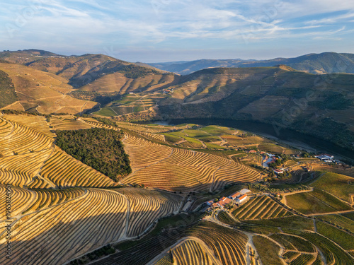 Foto Layered hills and terraced vineyards surround the Douro River in this aerial sunset view from Portugal's Douro Valley