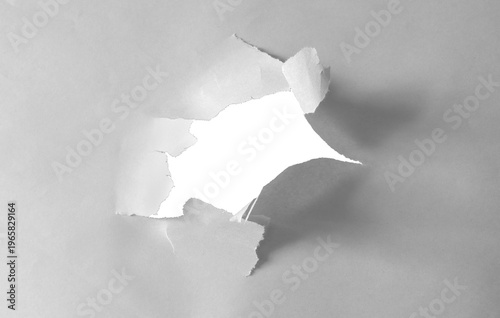 Ripped hole in newsprint with texture of torn paper edges isolated.