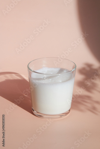 glass of milk on pink background