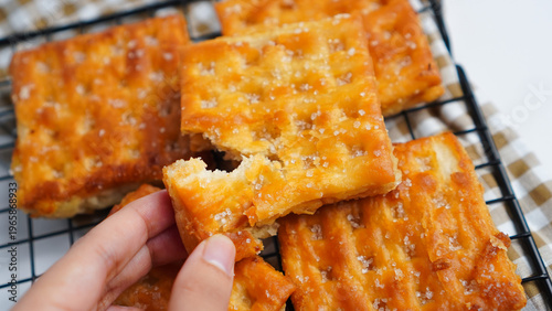A person is holding a piece of a salty snack