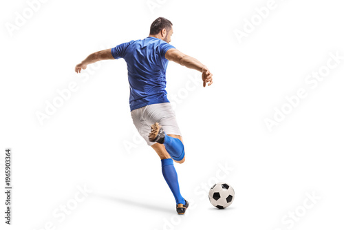 Fotografía Rear view shot of a football player in a blue jersey kicking a ball