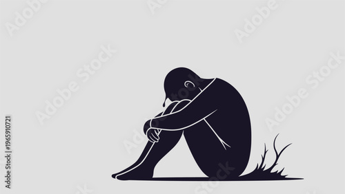 Silhouette of a person sitting in a crouched position representing themes of sadness loneliness and mental health awareness.
