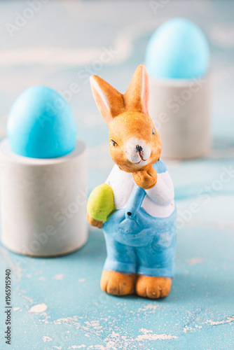 Cute decorative Easter bunny and blue easter eggs on a blue background