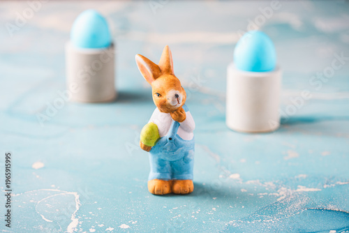 Cute decorative Easter bunny and blue easter eggs on a blue background
