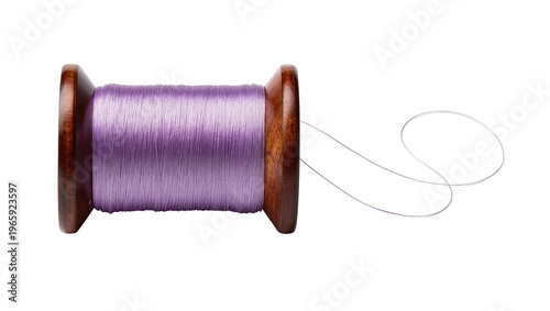 Tableau sur toile Wooden spool tightly wound with vibrant purple sewing thread a loose strand exte