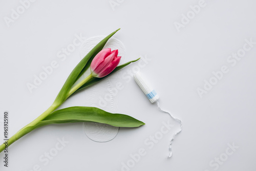 Eco friendly feminine hygiene concept with sanitary pad and tulip, copy space.
