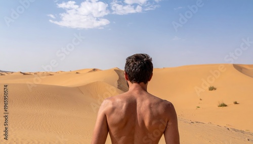 Mans Back in Desert Landscape Under Blue Sky with Clouds.
