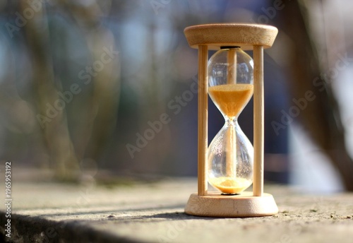 Hourglass on the stone surface concept of passing time hurry up live bein time 