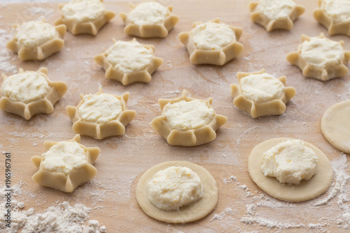 Preparation of Italian ricotta pastries showing dough circles and formed star shapes on floured wooden board