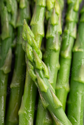 Gourmet macro shot of fresh blanched asparagus spears on dark slate background. Healthy spring vegetable with dramatic lighting.