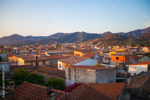 A dawn panorama of San Vito, highlighting its red‑tiled houses and the surrounding Sardinian mountain landscape.