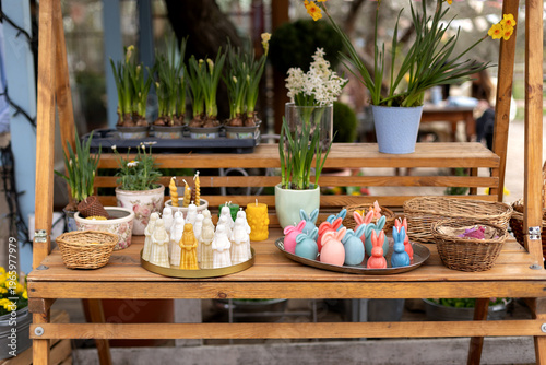 Wallpaper Mural Easter exterior market stall with spring flowers, wicker baskets, bunny shaped candles, and festive decorations. Cozy outdoor garden shop with blooming plants in pots and seasonal holiday display. Torontodigital.ca