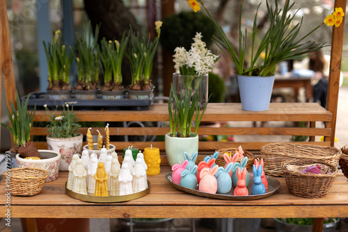 Wallpaper Mural Easter exterior market stall with spring flowers, wicker baskets, bunny shaped candles, and festive decorations. Cozy outdoor garden shop with blooming plants in pots and seasonal holiday display. Torontodigital.ca
