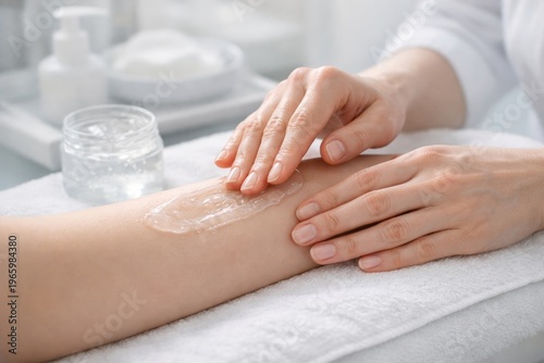 Closeup of hands applying moisturizing cream to forearm for skincare treatment and body care background for wellness design