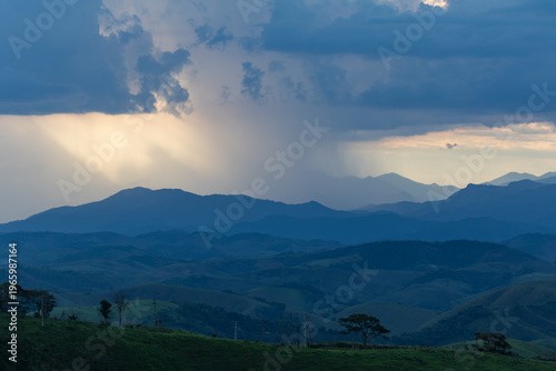 Foto Rain Showers Falling Over Distant Mountains Beneath Dramatic Cloudy Sky